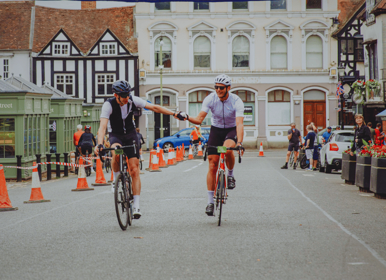 Two cyclists waving to the camera