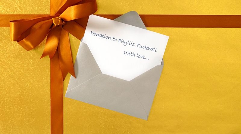 A gift box with a handwritten gift card saying donation to Phyllis Tuckwell, with love