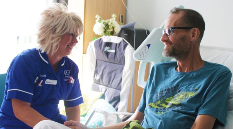 A nurse and patient smiling and chatting
