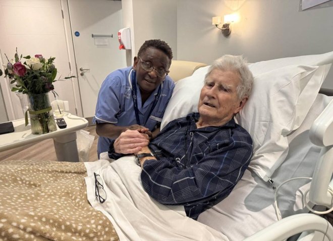 Hands cupped around a small lit candle