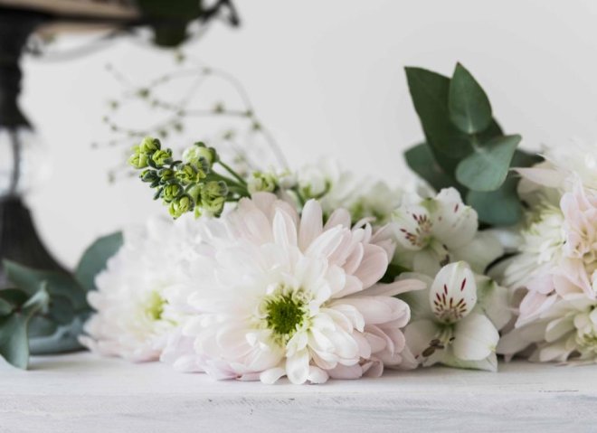 Hands cupped around a small lit candle