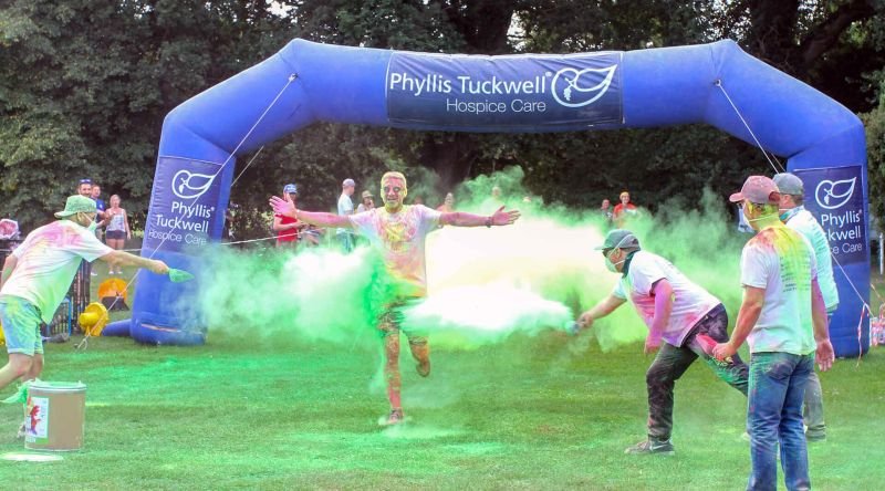 People throwing powder paint at a man who is running