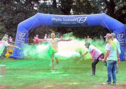 People throwing powder paint at a man who is running