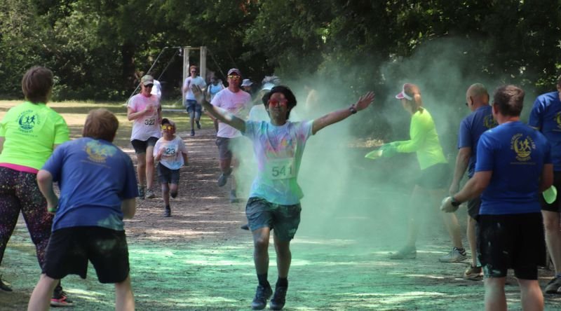 A person running, with people throwing powder paint