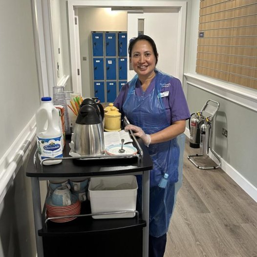 Smiling housekeeper with tea trolley
