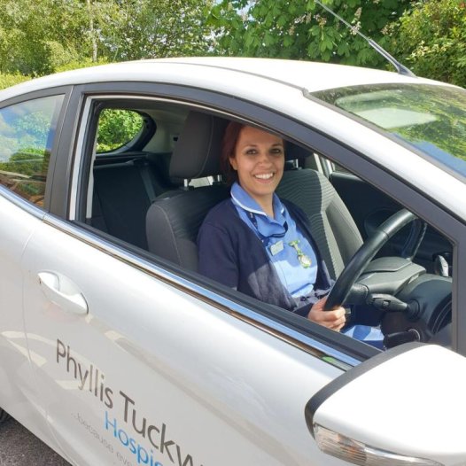 Smiling nurse in a car