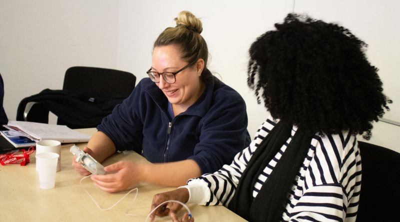 Two ladies looking at syringe pump