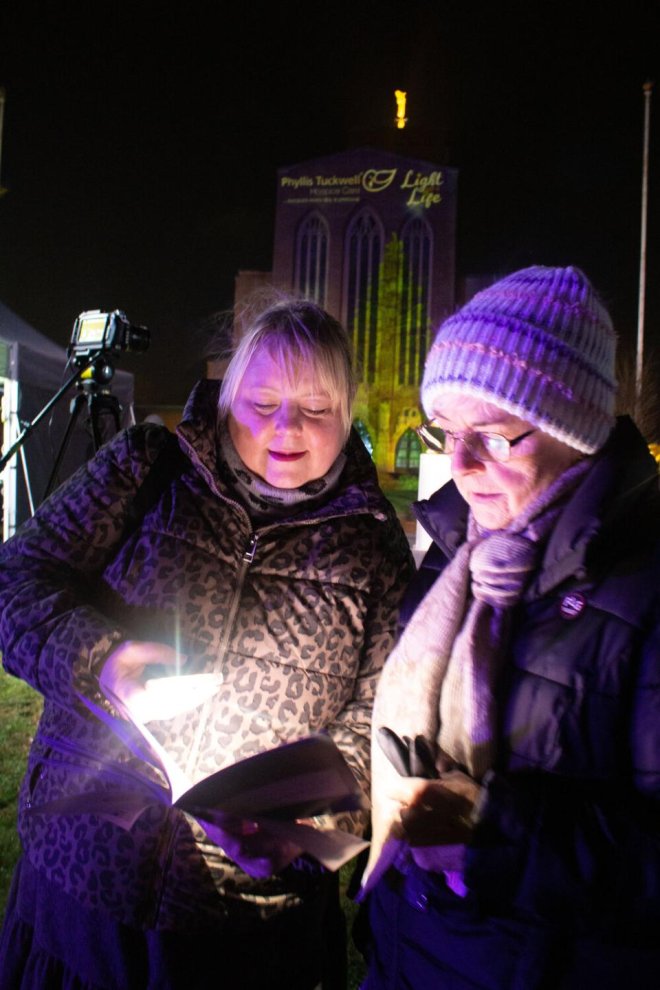 People looking at Light up a Life Order of Service