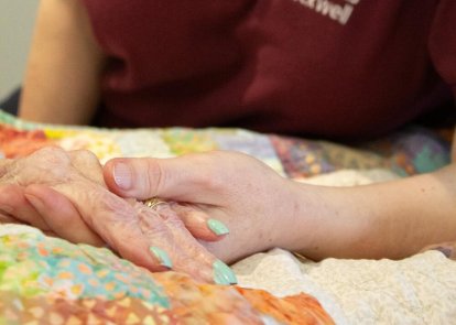 Chaplain holding patient's hand