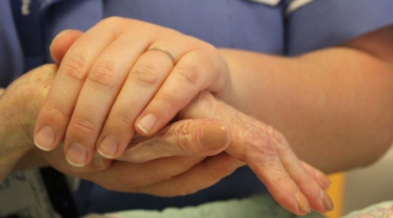 Nurse holding patient's hand