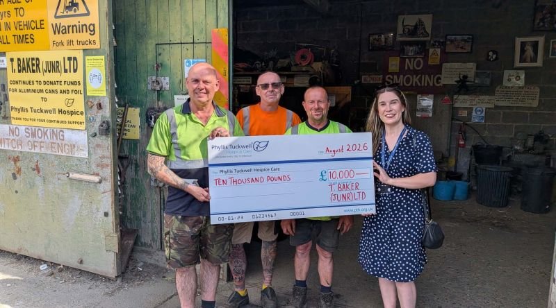 Four people with a big cheque