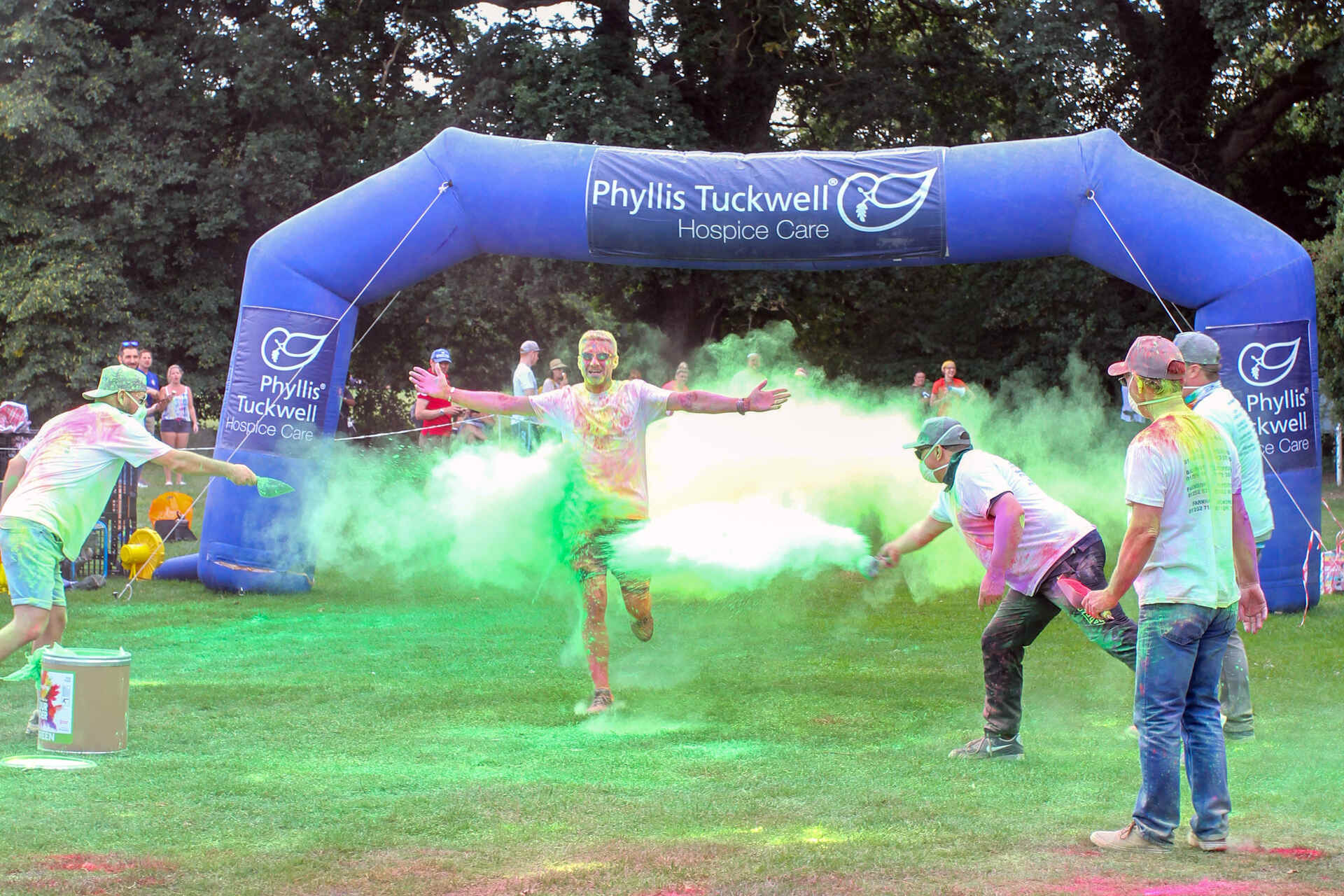 People throwing powder paint at a man who is running