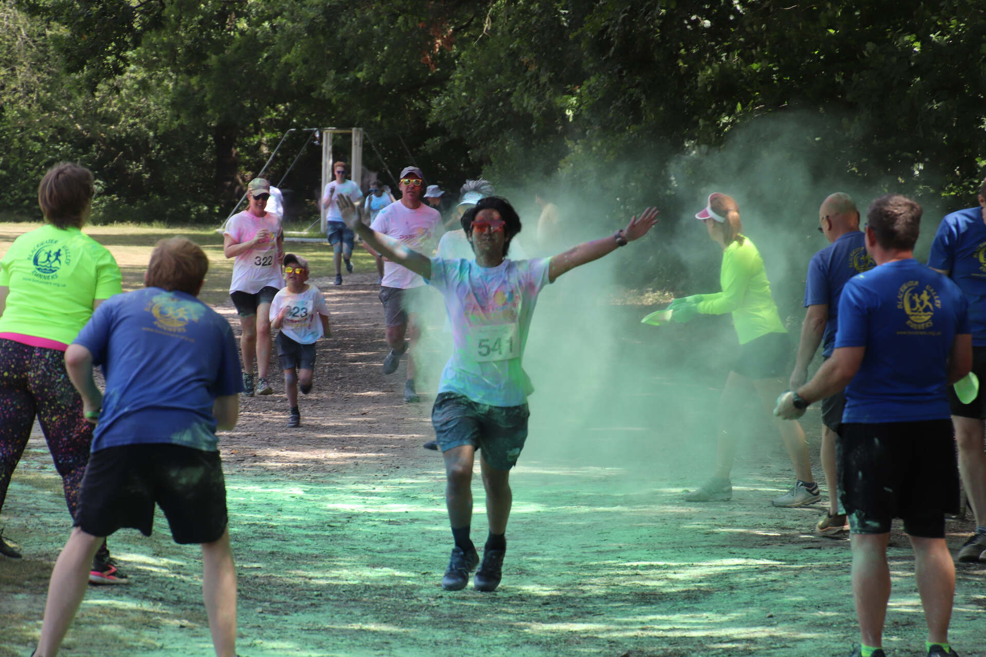 A person running, with people throwing powder paint